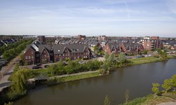 Bovenaanzicht van project Westwijk Amstelveen een woonwijk met rood gekleurde eengezinswoningen en appartementen langs het water