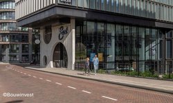 Vooraanzicht van hotel Casa een vierkant gebouw met een ingang in de vorm van een boog en veel ramen
