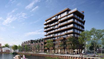 Een gebouw van 9 verdiepingen met lagere gebouwen eraan vast. Op de voorgrond is een kanaal.