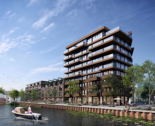 Een gebouw van 9 verdiepingen met lagere gebouwen eraan vast. Op de voorgrond is een kanaal.
