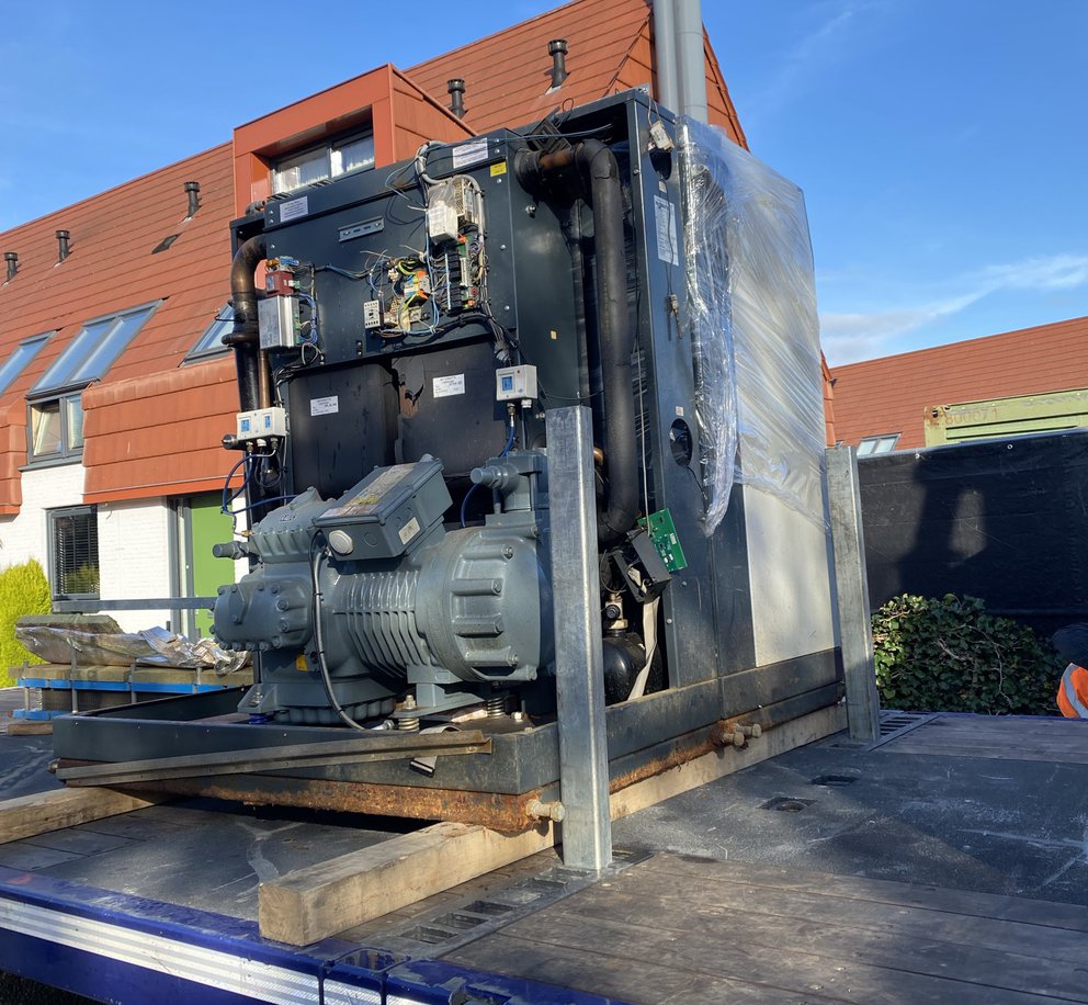 De oude centrale warmtepomp uit project De Beljaart in Dongen op een oplegger