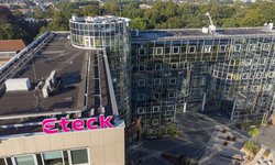 Bovenaanzicht van het kantoor gebouw van Eteck in Voorburg met het roze Eteck logo op het dak en op de achtergrond veel groen